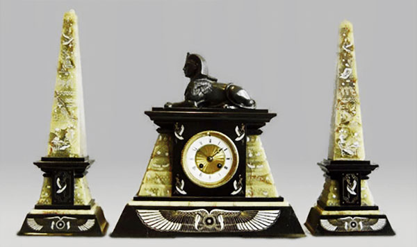 chiếc đồng hồ trang trí kiểu lăng mộ Ai Cập cổ đại ngay phía dưới bức tượng nữ thần Isis cùng hai tòa tháp với kiến trúc Obelisks đặt hai bên 
